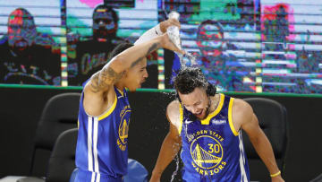 SAN FRANCISCO, CALIFORNIA - APRIL 12: Stephen Curry #30 of the Golden State Warriors is doused with water by Juan Toscano-Anderson #95 of the Golden State Warriors after their win over the Denver Nuggets at Chase Center on April 12, 2021 in San Francisco, California. Curry passed Wilt Chamberlain as the Golden State Warriors all-time leading scorer during the first quarter of their game. NOTE TO USER: User expressly acknowledges and agrees that, by downloading and or using this photograph, User is consenting to the terms and conditions of the Getty Images License Agreement. (Photo by Ezra Shaw/Getty Images)